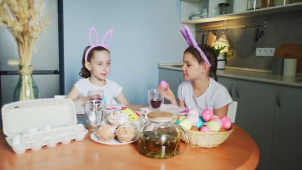 Irmãzinhas engraçadas colocar ovos coloridos na cesta no dia de Páscoa — Vídeo de Stock