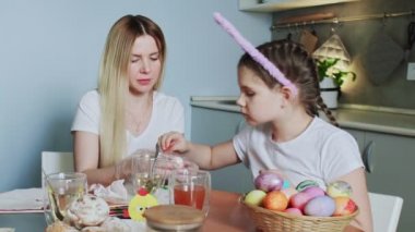 Mutlu Paskalyalar. Aileyi Paskalya 'ya hazırlıyorum. Anne kızıyla birlikte Paskalya yumurtalarını boyuyor..