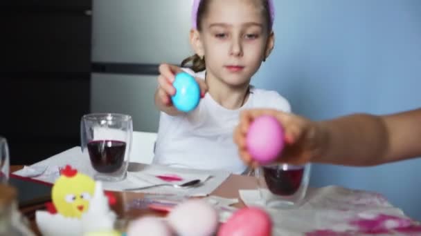 Zabawne siostrzyczki wkładają kolorowe jajka do kosza na Wielkanoc — Wideo stockowe