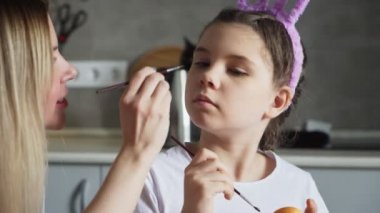 Mutlu Paskalyalar. Anne kızıyla oynamak için boya fırçası kullanıyor.