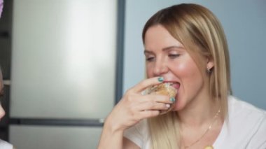 Mutlu Paskalyalar. Aileyi Paskalya 'ya hazırlıyorum. Anne ve küçük kızları çay içip kek yiyorlar.