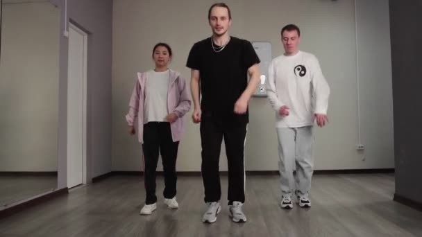 Jedna žena a dva muži tančí hip hop, volný styl mladistvého současného tance v tanečním studiu. — Stock video