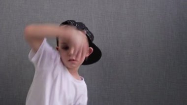 Beyaz çocuk dans ederek zıplıyor. Yeteneğin ve hobinin ifadesi. Mutlu bir çocukluk. Rhythm 'de müzik dinleyip dans eden ergen çocuk.