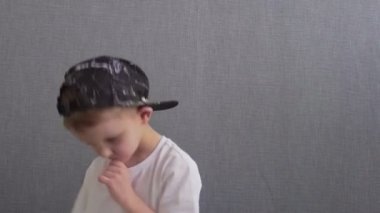 Beyaz çocuk dans ederek zıplıyor. Yeteneğin ve hobinin ifadesi. Mutlu bir çocukluk. Rhythm 'de müzik dinleyip dans eden ergen çocuk.