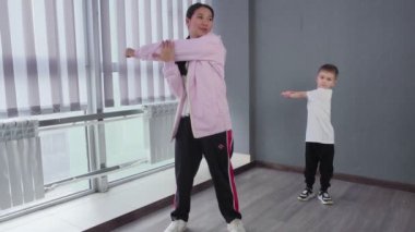 Küçük çocuk, break dans hip-hop dans dersine hazırlanmak için egzersiz yapıyor.