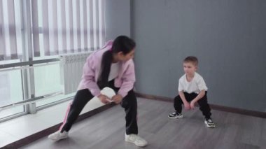 Küçük çocuk, break dans hip-hop dans dersine hazırlanmak için egzersiz yapıyor.