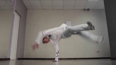 Genç break dansçı stüdyoda hip hop dansı yapıyor. Yakışıklı adam yerde dans hareketleri yapıyor.