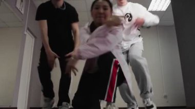 Yaratıcı genç kadın ve erkekler modern sanat stüdyosunda dans ediyorlar.