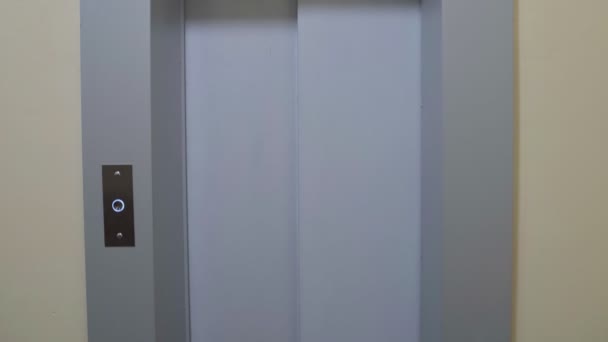 Молодой человек в белой рубашке выходит из лифта с картонными коробками, переезжающими в новую квартиру — стоковое видео