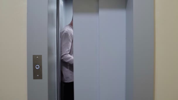 Pasangan muda keluar dari lift dengan kotak kardus dan kursi lipat pindah ke apartemen baru — Stok Video
