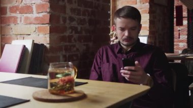 Çin Çay Kafesi 'nde cep telefonu kullanan genç adam.