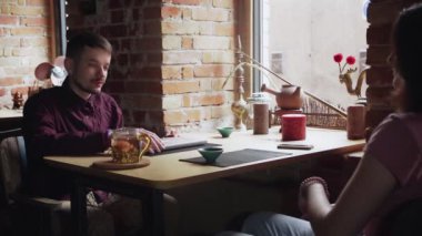 Çin Çay Kafesi 'nde birlikte çalışan genç bir çift dizüstü bilgisayar kullanıyor.