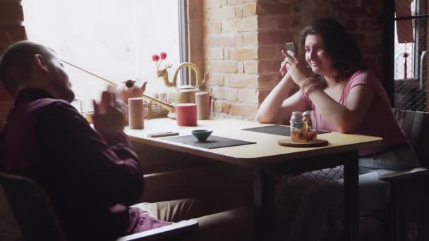 A mulher tira uma foto do namorado. Namoro casal relaxante juntos no café chá chinês — Vídeo de Stock