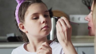 Mutlu Paskalyalar. Anne kızıyla oynamak için boya fırçası kullanıyor.