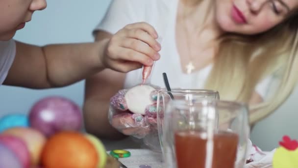 Happy Easter. Preparing the family for Easter. Woman with little girls paints Easter eggs. — Stock Video