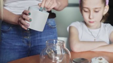 Mutlu Paskalyalar. Aileyi Paskalya 'ya hazırlıyorum. Kadının biri ailesi için cam çaydanlıkta çay yapıyor.