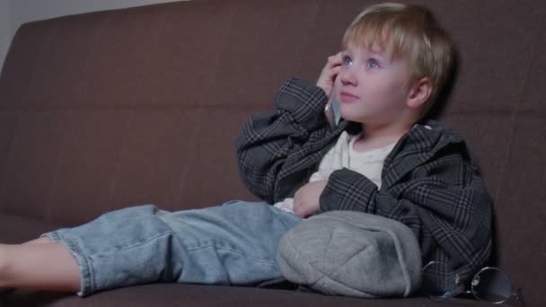 Carino bambino bambino bambino utilizzando un telefono per parlare con la madre a casa — Video Stock