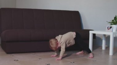 Sevimli çocuk dans ediyor ve zıplıyor evde eğleniyor.