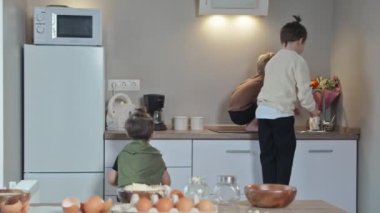 Üç kardeş mutfakta kahvaltıda krep pişirdikten sonra el yıkıyorlar..