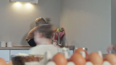 Küçük çocuk kahvaltıdan sonra masaya oturur ve ellerini yıkar.