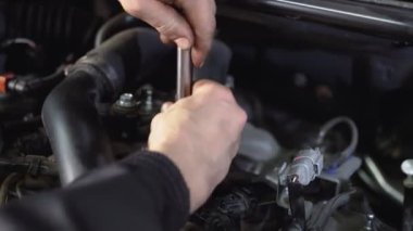 Motoru ve araba servisini tamir etmek için ingiliz anahtarı kullanarak araba tamircisini kapat..