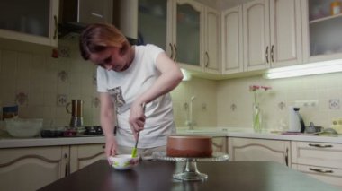 Ev hanımı pasta süslemek için çikolata jölesi hazırlar.