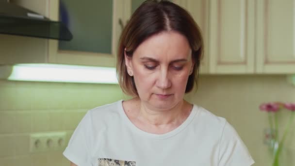 Mujer comiendo galletas de chocolate en la cocina — Vídeo de stock