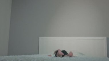 Mutlu çocuk geceleri yatakta zıplıyor.