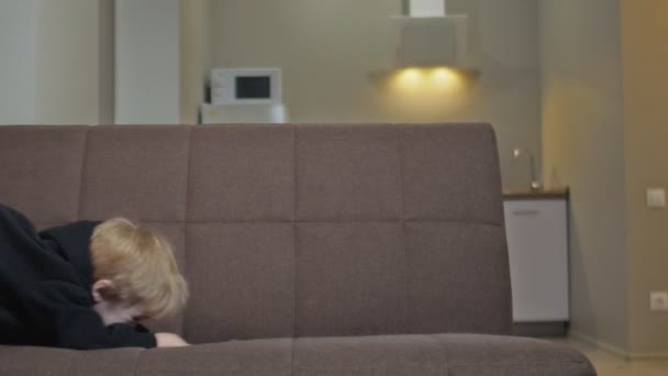 Little boy have fun at home. Little boy plays on couch — Stock Video