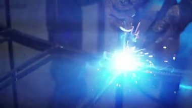 Sanatsal sahtecilik. Dekoratif bir metal ürünü üretme süreci. Metal kıvılcımlar detaylardan uzaklaşır. Dekoratif metal ürünleri oluşturma sürecinde metalin kaynaklanması.