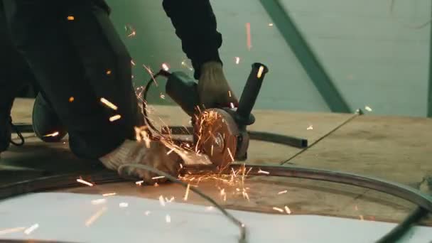 Художник-кузнец использует мельницу для резки металла на открытом воздухе — стоковое видео