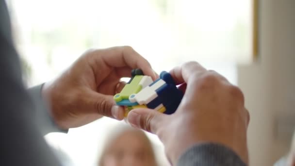 Primer plano del hombre muestra su rompecabezas a los niños en la sala de clase — Vídeos de Stock