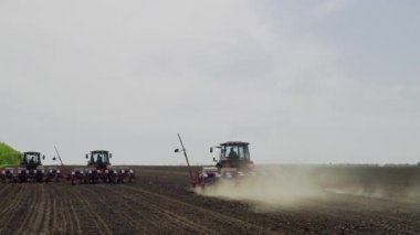 Hasat alanındaki traktör, yükseklikten en iyi görüntü. Quadrocopter traktöründen ateş etmek büyük bir tarlaya buğday ekmek için toprağı sürmektir.