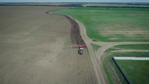 빨간 트랙터를 타고 있는 농부 가작은 밭에서 쟁기 질을 한다. 농사를 짓는 일 — 비디오