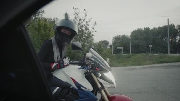 Jeune femme dans un casque noir assis vagues main et montre le cœur à la caméra — Video