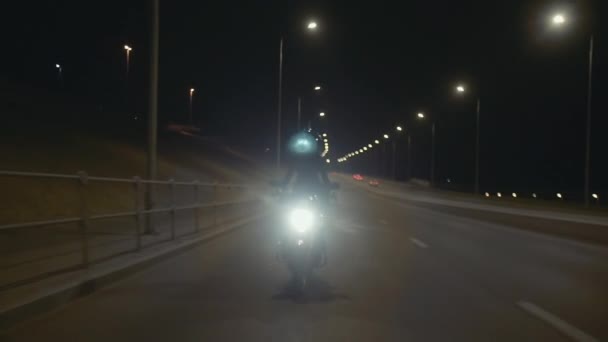 Giovane donna pazza in un casco nero fa trucchi sulla moto di notte — Video Stock