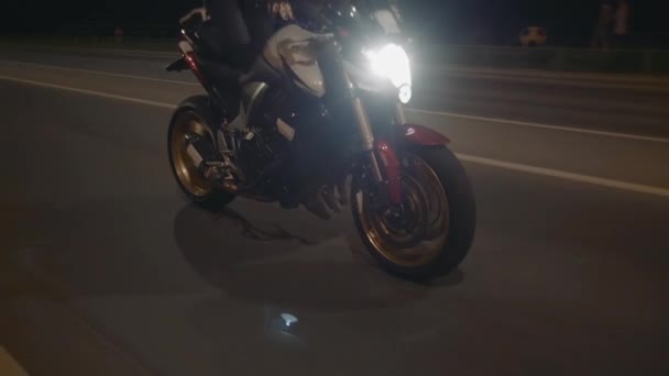 Mladá žena cyklistka jezdí na motorce v helmě na silnici, pohled zepředu. — Stock video