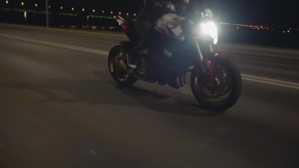 Vista laterale della giovane donna che guida moto sulla strada di notte — Video Stock