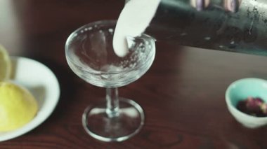 Bir kadın eli kadehten bardağa su doldurur.