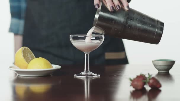 Una mano de mujer vierte una bebida de un agitador en un vaso — Vídeos de Stock