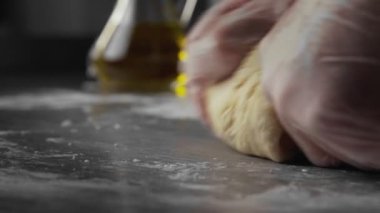 Fırıncı un içinde hamur yoğuruyor. Un ile yumurtayı karıştırma ve yoğurma işlemi.