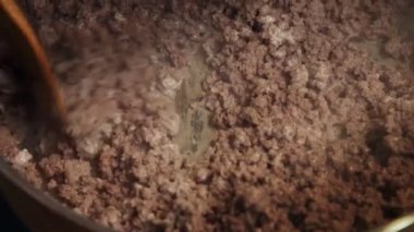 Şef kızartma tavasında et doğruyor.