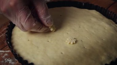 Profesyonel şef etten turta yapar. Şef pastayı hamurdan çiçeklerle süslüyor.