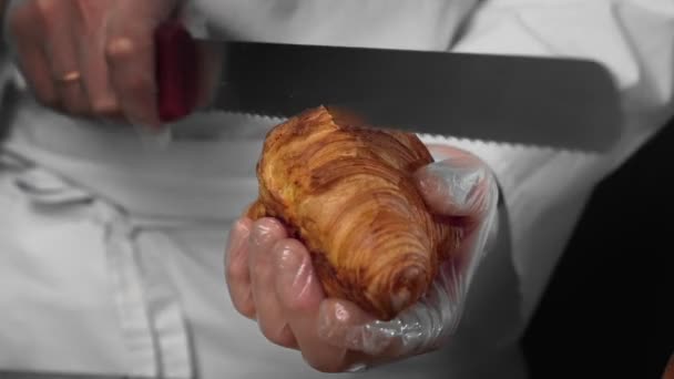 Chef corta croissant para fazer sanduíche — Vídeo de Stock