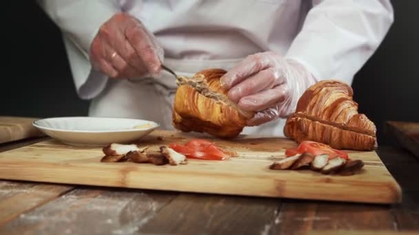 Close up de chef faz um delicioso sanduíche croissant. — Vídeo de Stock