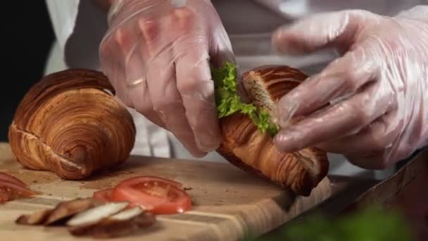 Zblízka šéfkuchař dělá vynikající croissant sendvič. — Stock video
