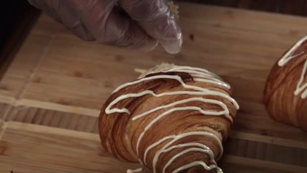 Obchodní pekárna. Kuchař zdobí croissanty pomocí tašky na vaření. — Stock video