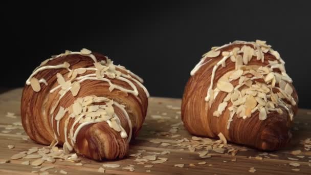 Dva francouzské croissanty, sladký a slaný dezert na dřevěné desce, ochucené mňam s čokoládovou náplní. Zpomalený pohyb, 4K. — Stock video