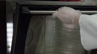 Profesyonel şef etten turta yapar. Şef pastayı fırına koyar.