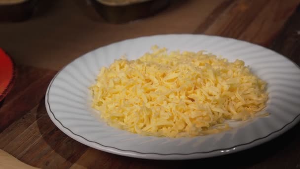 Grated cheese parmesan on a white plate — Stock Video